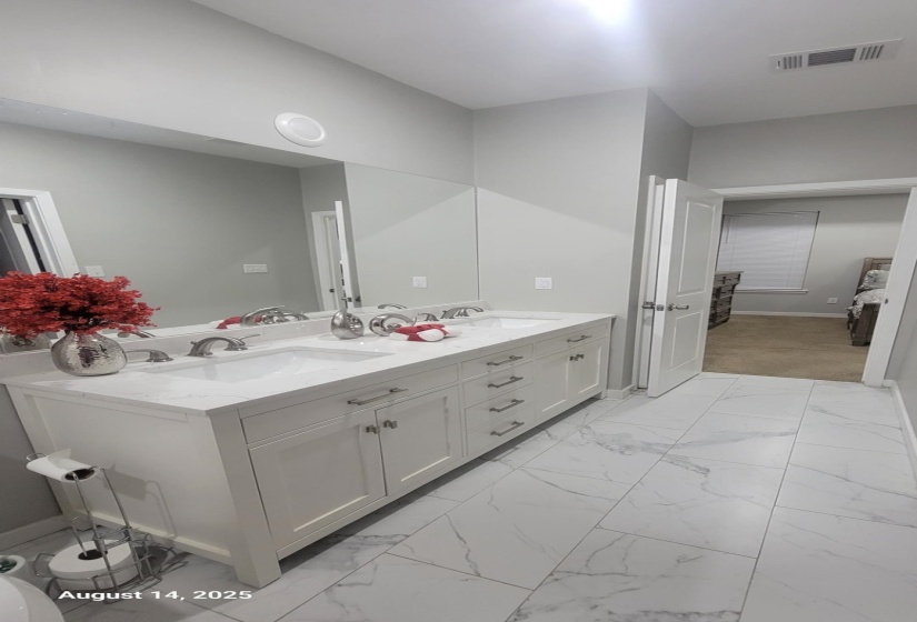 Bathroom with light marble finish floors and double vanity