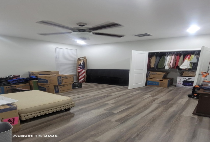 Bedroom with wood finished floors, a ceiling fan, and a closet