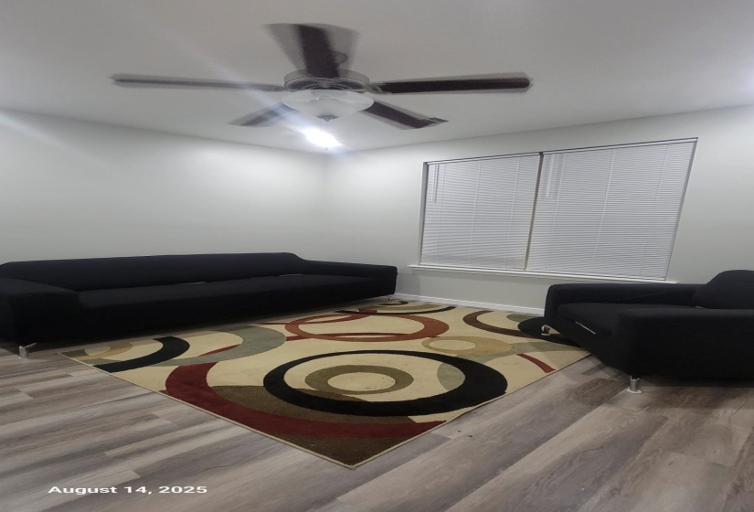 Living area with wood finished floors and ceiling fan