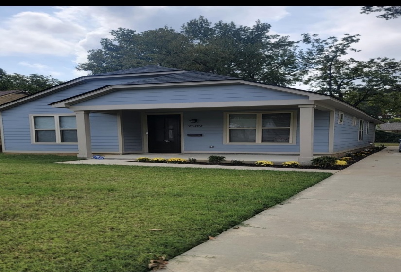View of front of property with covered porch and a front lawn