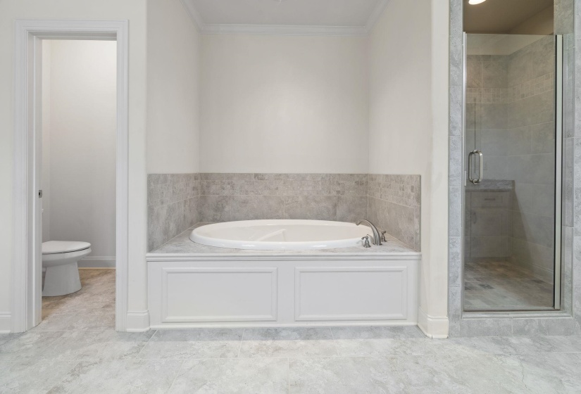 Bathroom with a bath, a shower stall, and ornamental molding