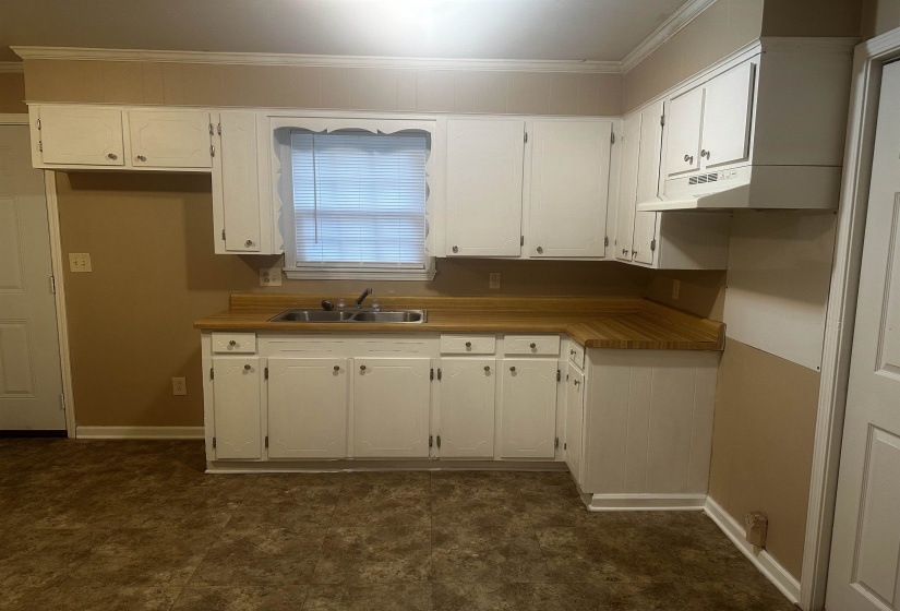 Kitchen featuring ornamental molding, white cabinets, and under cabinet range hood
