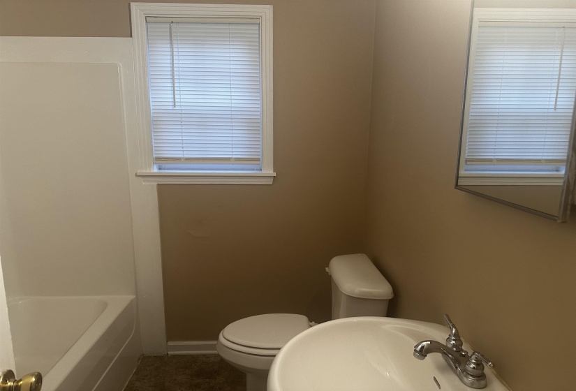 Full bath featuring toilet and dark tile patterned floors