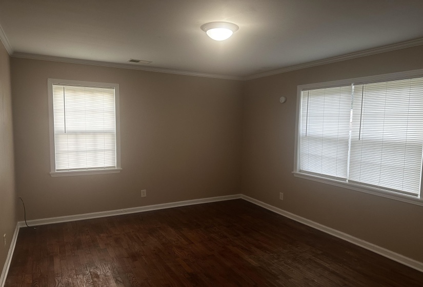 Unfurnished room featuring dark wood-style flooring and crown molding
