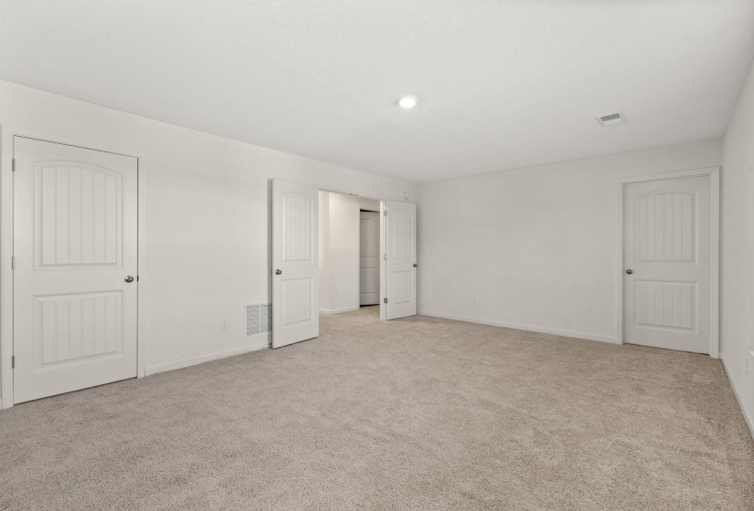 Unfurnished bedroom with light colored carpet and baseboards