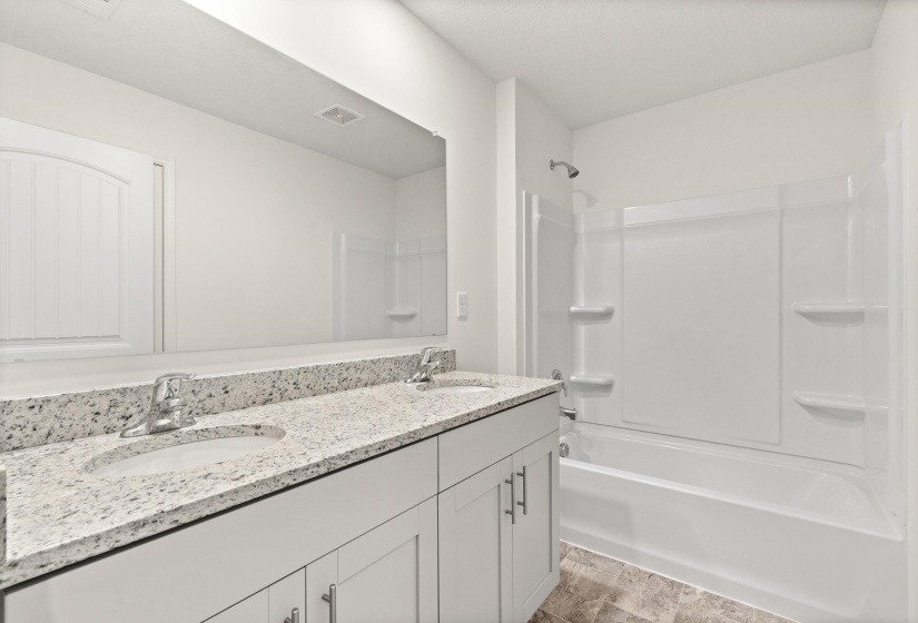 Bathroom with double vanity and bathtub / shower combination