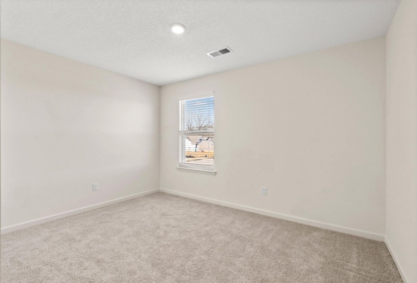 Empty room featuring light carpet and a textured ceiling