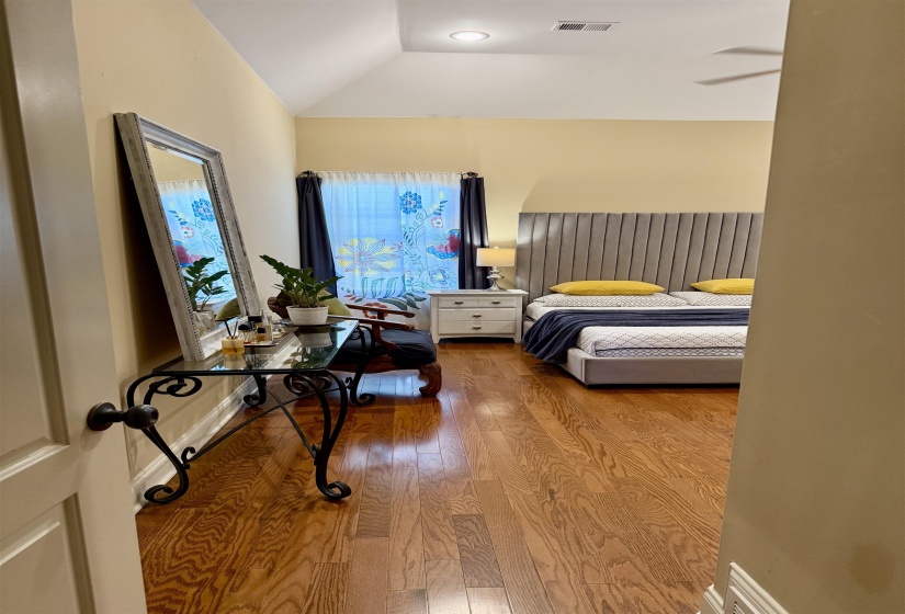 Bedroom with wood finished floors and lofted ceiling