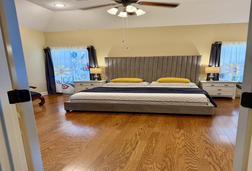 Bedroom featuring wood finished floors, a ceiling fan, and lofted ceiling