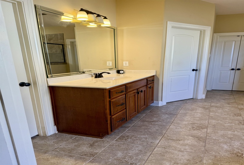 Bathroom featuring vanity, a shower with door, and light tile patterned flooring