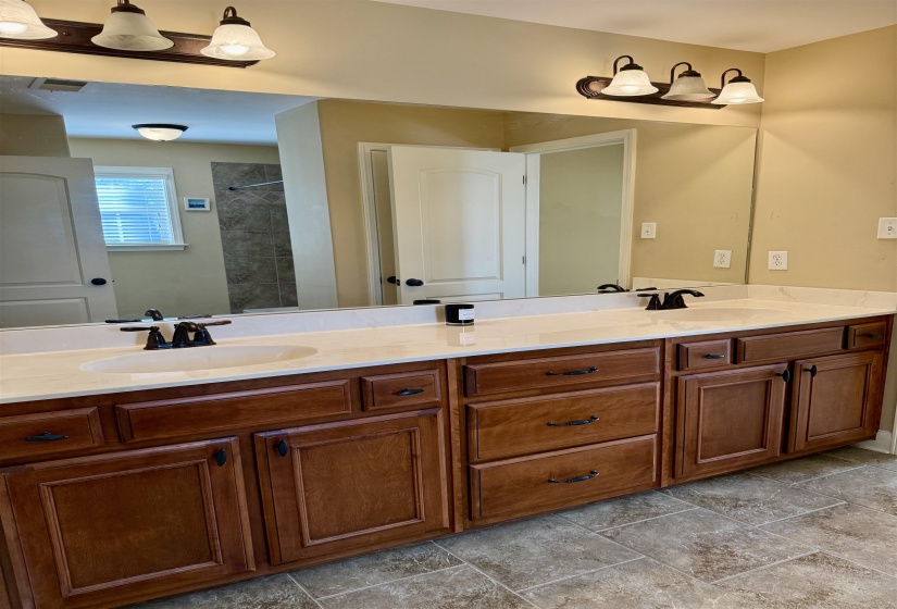 Bathroom featuring double vanity and tiled shower