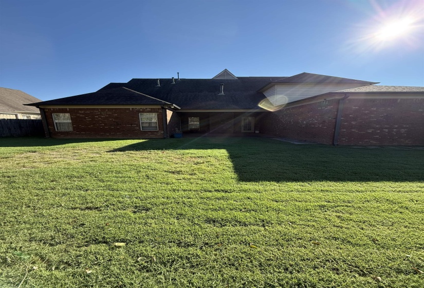 Back of property with brick siding and a patio area