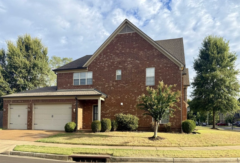 Traditional-style home with a front lawn, brick siding, concrete driveway, and a shingled roof