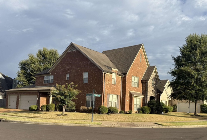 Traditional-style house with brick siding, a front yard, and a garage