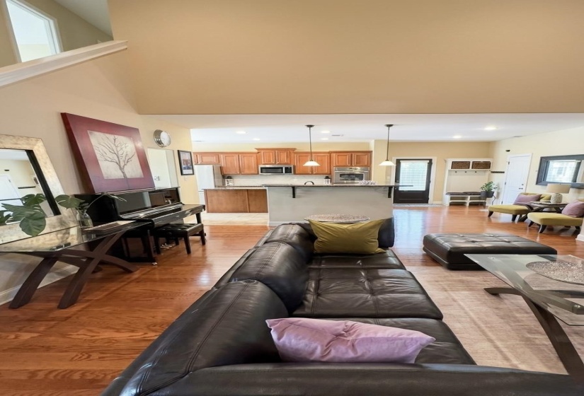 Living room featuring light wood finished floors, recessed lighting, and a high ceiling