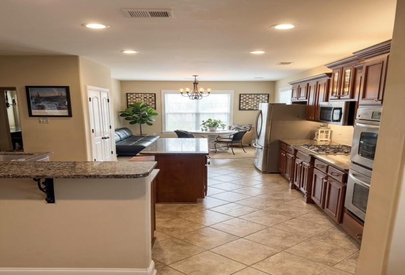 Kitchen with a kitchen island, a breakfast bar area, stainless steel appliances, and dark stone counters