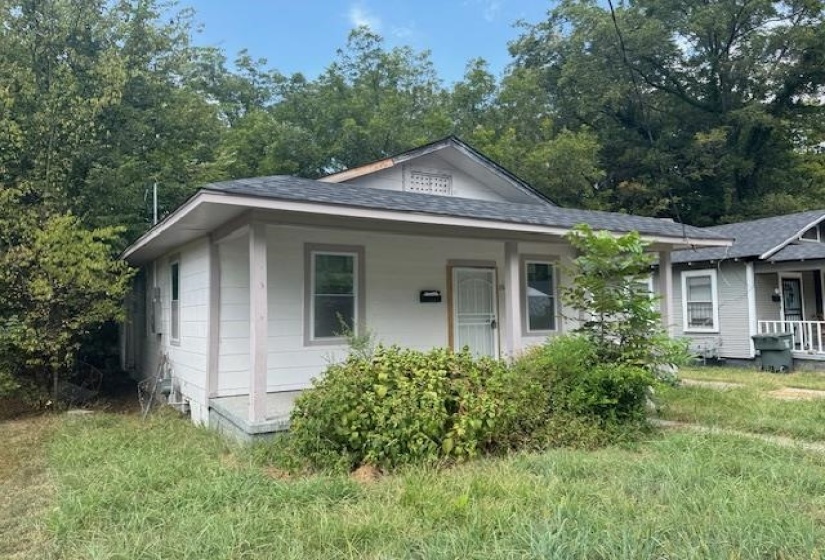 Bungalow-style house with covered porch, roof with shingles, and a front lawn