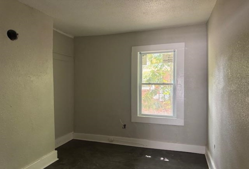 Empty room with a textured wall and a textured ceiling