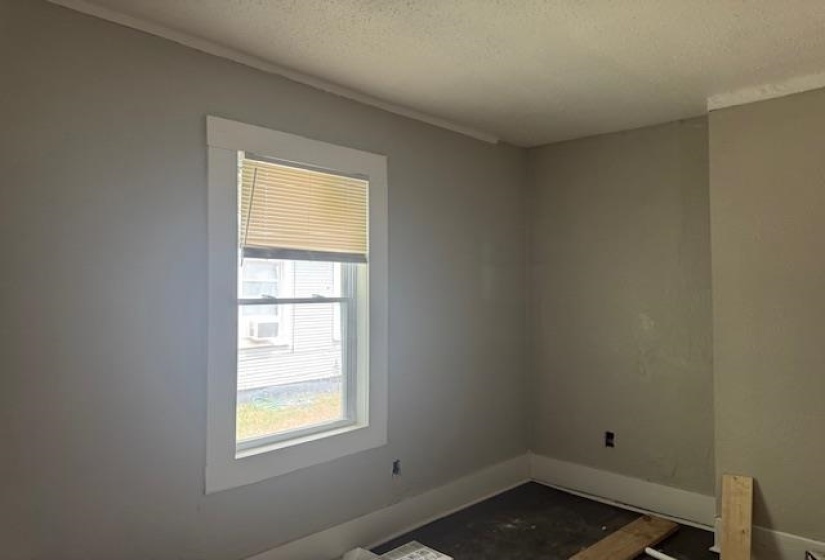 Unfurnished room featuring a textured ceiling and ornamental molding