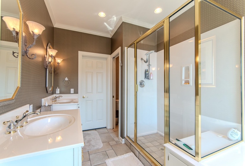 Bathroom with ornamental molding, double vanity, wallpapered walls, a stall shower, and recessed lighting