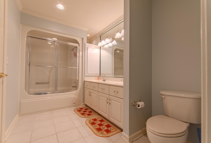 Full bath featuring light tile patterned floors, crown molding, vanity, shower / bath combination with glass door, and recessed lighting