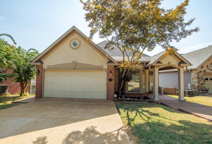 Ranch-style house featuring concrete driveway, brick siding, a shingled roof, and a garage