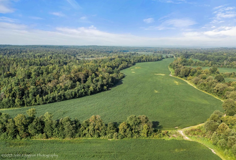 Aerial view of property and surrounding area featuring a forest