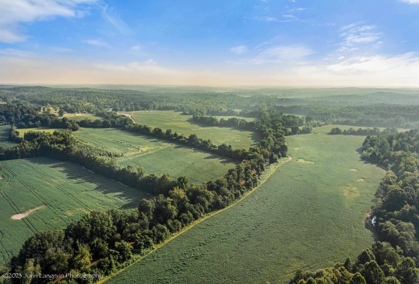 Aerial overview of property's location featuring rural landscape and a forest