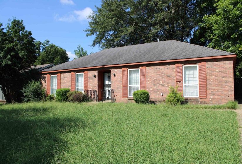 Ranch-style home featuring brick siding, a front lawn, and a shingled roof