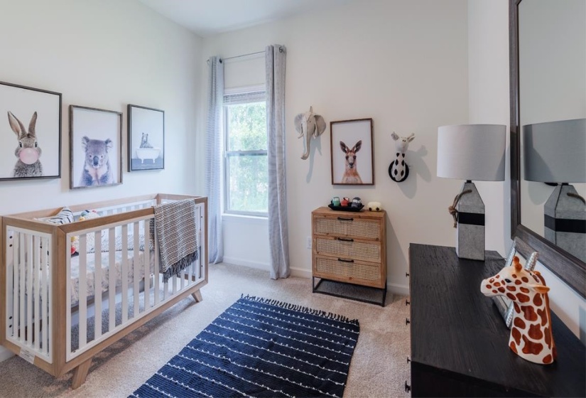 Bedroom featuring light colored carpet and a crib
