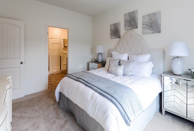 Bedroom featuring ensuite bathroom and light colored carpet