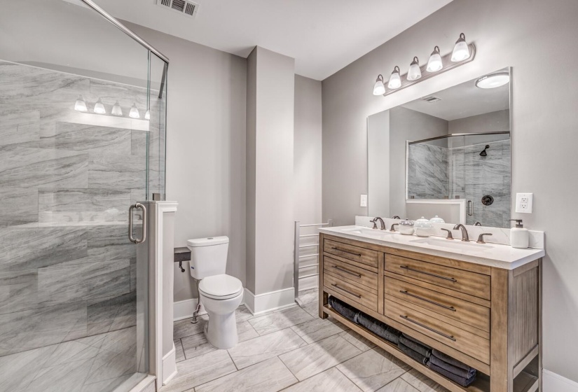 Bathroom featuring double vanity and a shower stall