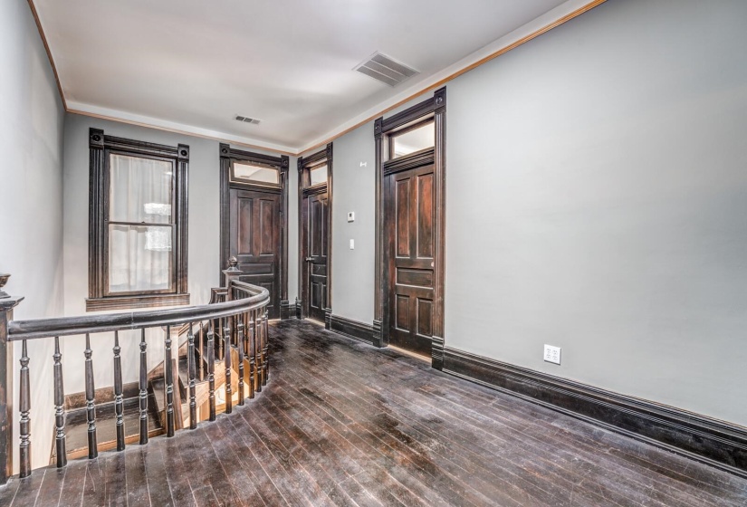 Entryway featuring crown molding and dark wood-style flooring