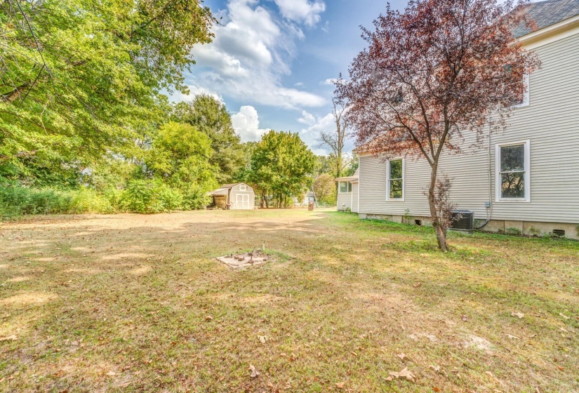 View of green lawn with a storage shed