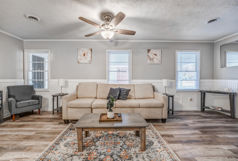 Living room featuring a textured ceiling, hardwood / wood-style flooring, and crown molding