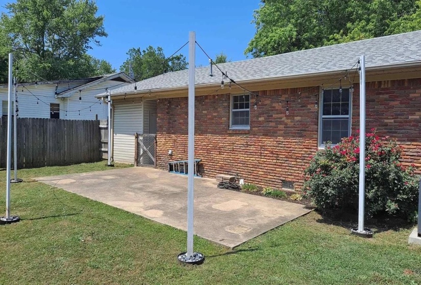Back of property with a patio area, brick siding, crawl space, and roof with shingles