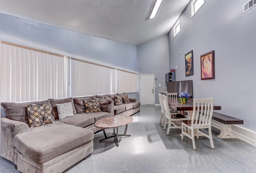 Living room featuring a towering ceiling and a textured ceiling