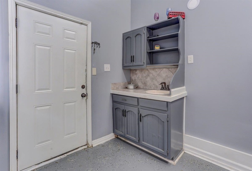 Laundry room featuring baseboards and a sink