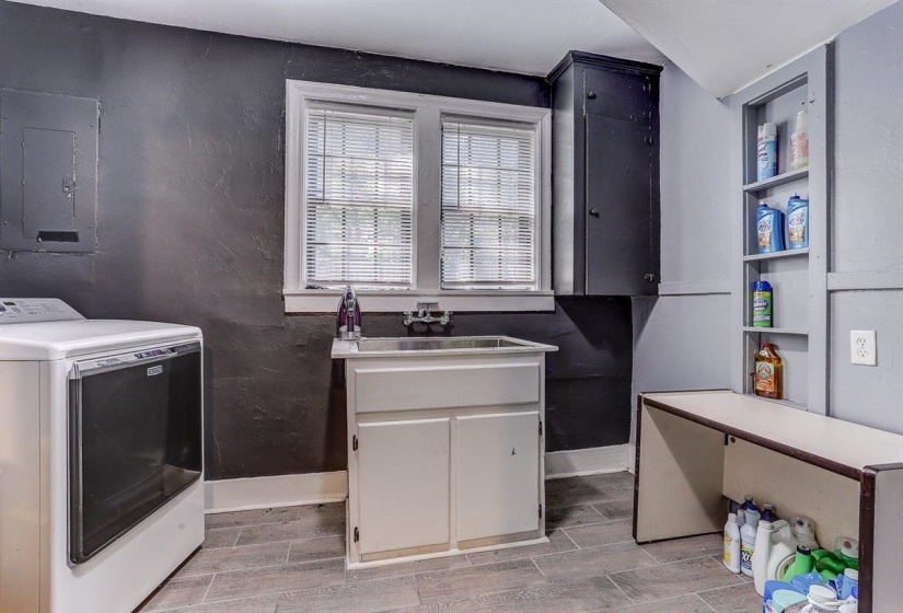 Laundry area featuring washer / dryer, electric panel, and wood finish floors