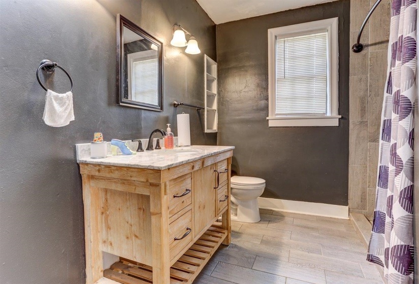 Bathroom featuring vanity, light wood-style floors, and a shower with curtain