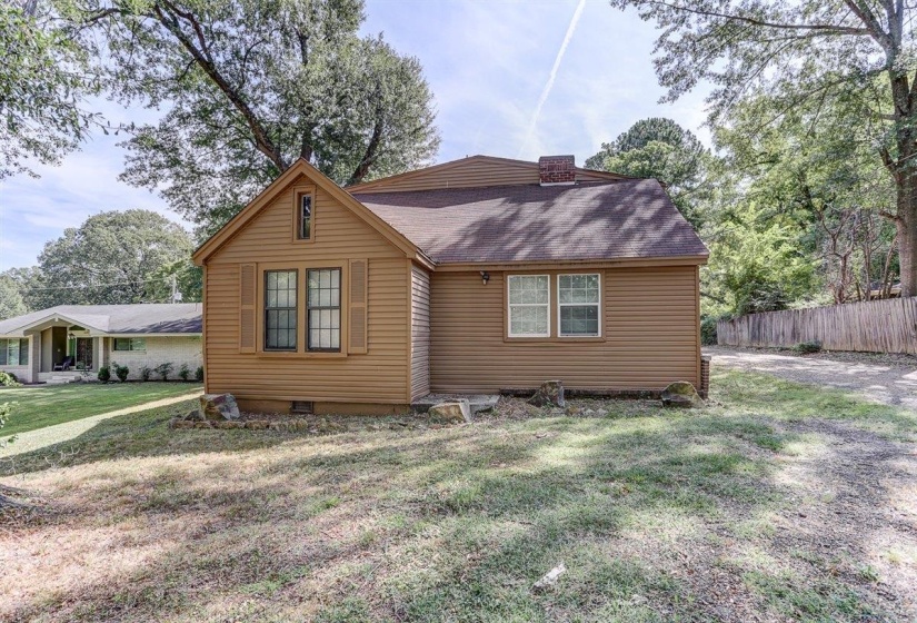 View of front of house with a shingled roof, crawl space, and a chimney