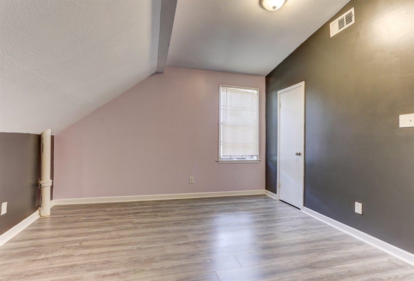 Additional living space with a textured ceiling and light wood finished floors