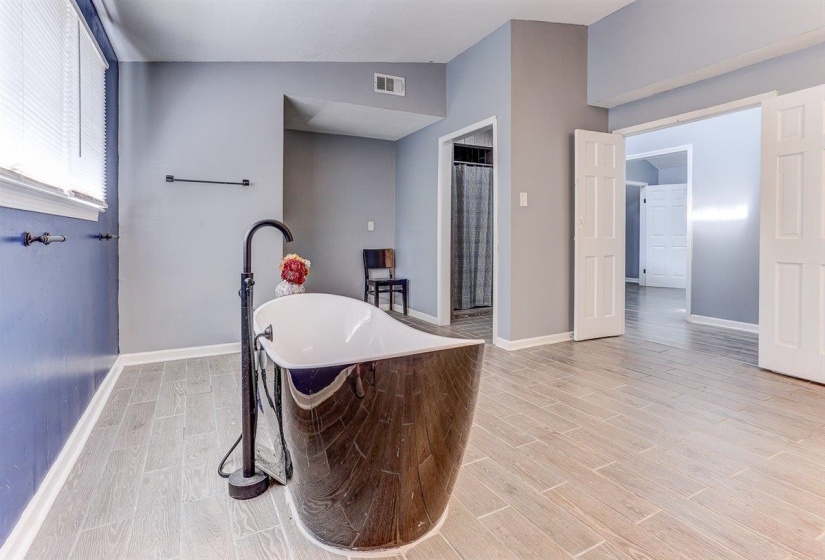 Bathroom featuring a soaking tub, wood tiled floors, a shower stall, and vaulted ceiling