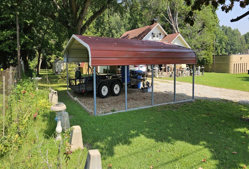 View of parking with a detached carport and driveway