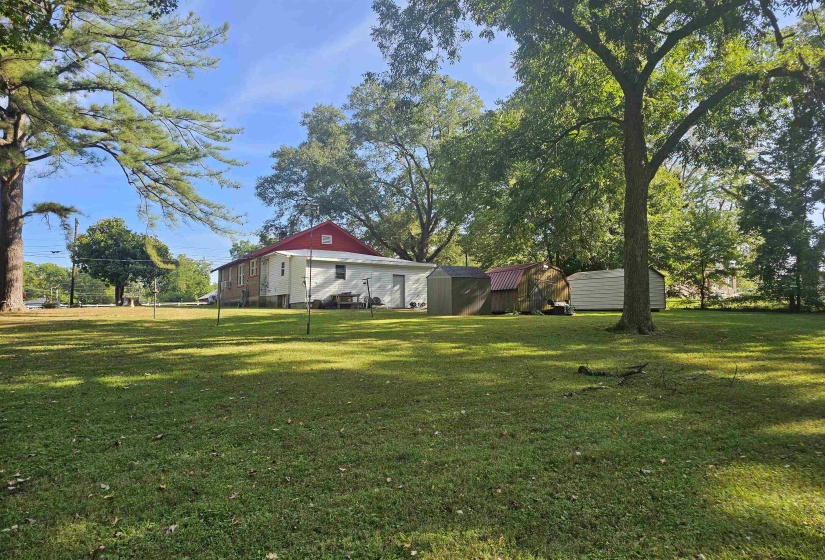 View of grassy yard featuring a storage unit