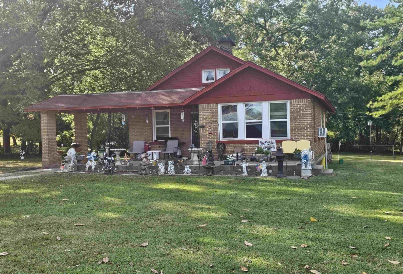Rear view of house with a lawn, brick siding, and a patio
