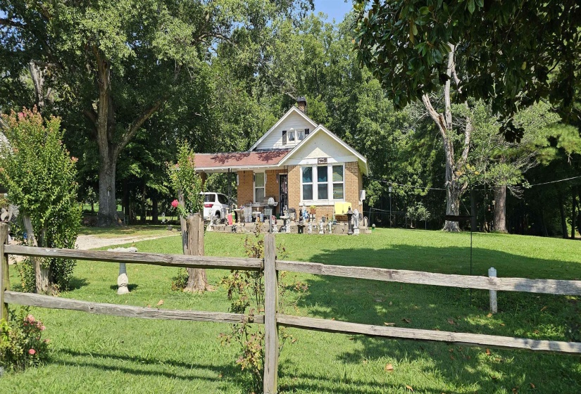 View of front facade featuring brick siding, a fenced front yard, and a porch