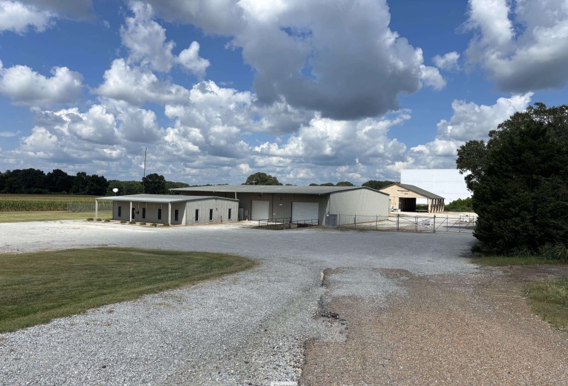 Ranch-style home with a garage, gravel driveway, and covered porch
