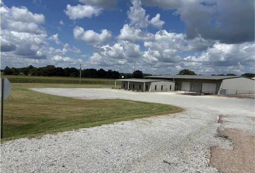 View of home's community featuring a garage, a lawn, and gravel driveway
