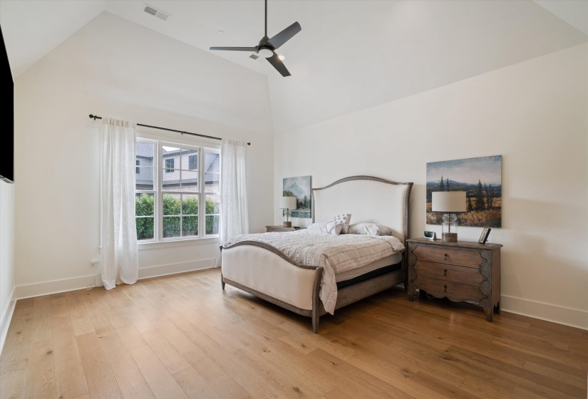 Bedroom featuring light wood-style floors, ceiling fan, and high vaulted ceiling